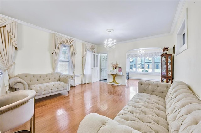 living room featuring a notable chandelier, wood-type flooring, and ornamental molding