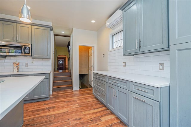33 Wellington Ct, Brooklyn, NY 11230 - kitchen with stainless steel microwave, a wall mounted AC, tasteful backsplash, light countertops, and recessed lighting