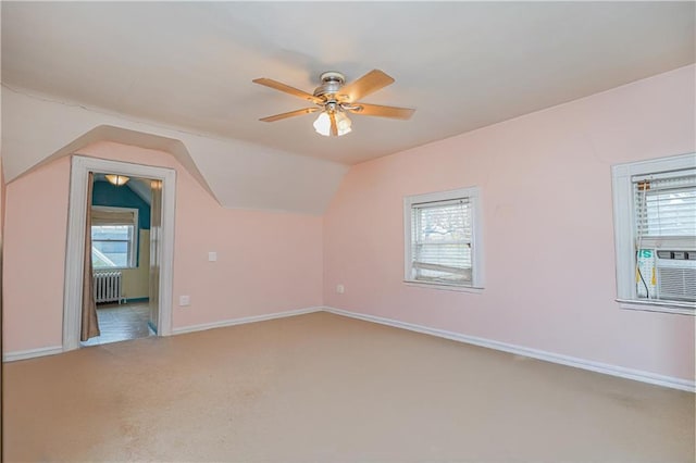 additional living space featuring radiator heating unit, carpet flooring, ceiling fan, and plenty of natural light