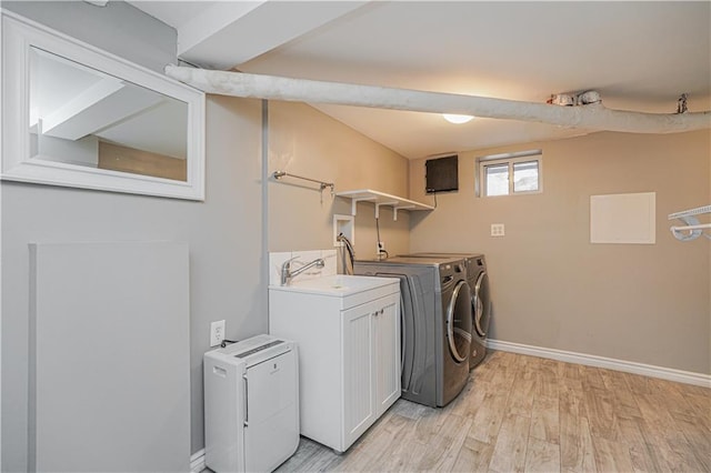 laundry room with baseboards, laundry area, light wood-style flooring, and independent washer and dryer