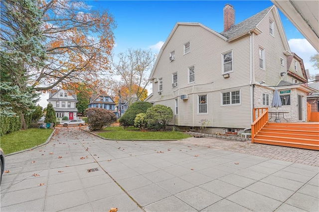 33 Wellington Ct, Brooklyn, NY 11230 - back of property featuring a chimney, a wooden deck, a patio, and a residential view
