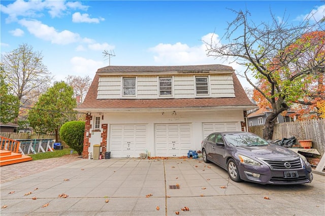 garage with fence and concrete driveway