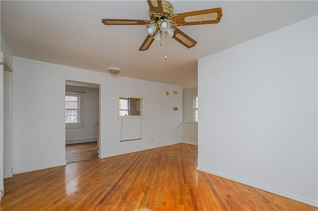 unfurnished room featuring baseboards, ceiling fan, and light wood-style floors
