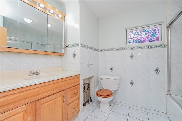 33 Wellington Ct, Brooklyn, NY 11230 - bathroom featuring tile patterned flooring, tile walls, toilet, vanity, and wainscoting