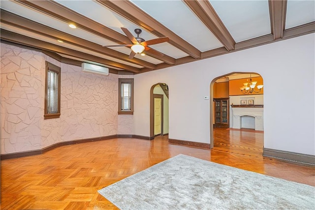 spare room featuring an AC wall unit, beam ceiling, arched walkways, baseboards, and ceiling fan with notable chandelier