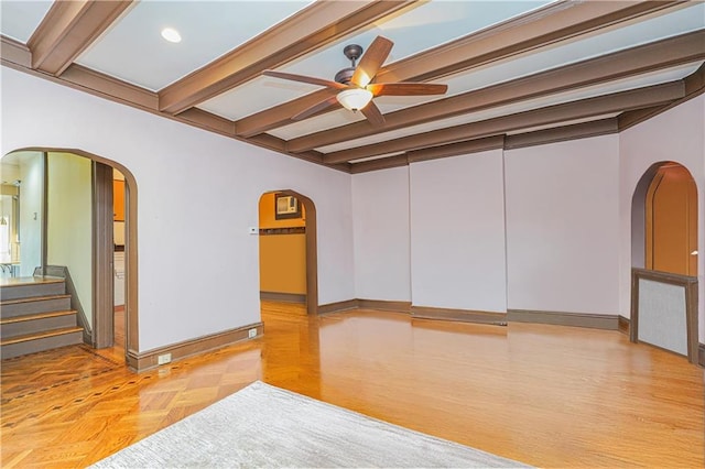 spare room with beamed ceiling, baseboards, arched walkways, and ceiling fan