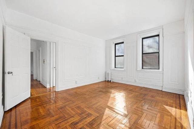 empty room with radiator heating unit and parquet flooring