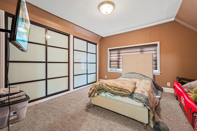 carpeted bedroom with lofted ceiling