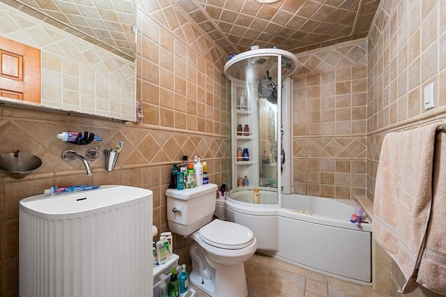 bathroom featuring toilet, tub / shower combination, and tile walls