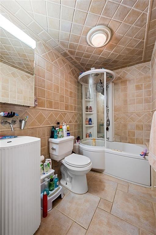 bathroom featuring backsplash, shower / bath combination, tile walls, and toilet