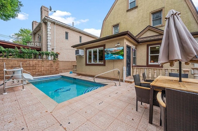 back of property featuring a wall mounted AC, a patio area, fence, and stucco siding