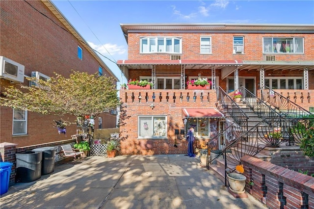 view of front of home featuring a patio and brick siding