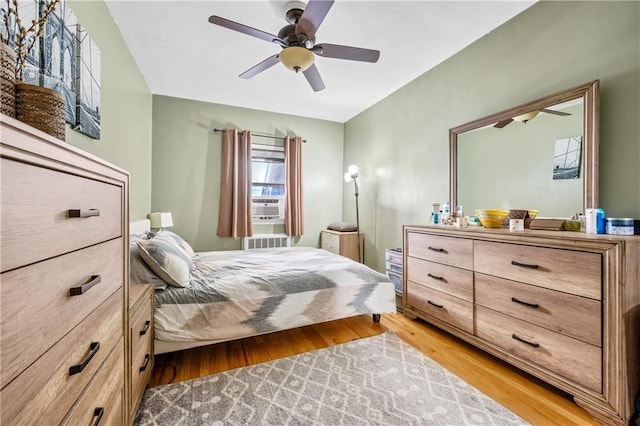 bedroom featuring a ceiling fan, multiple windows, and light wood-type flooring