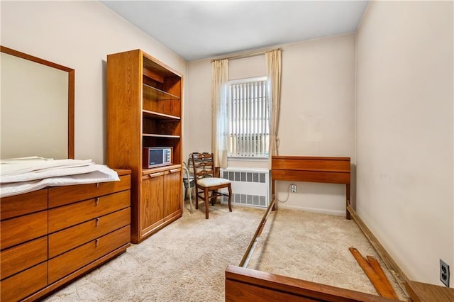bedroom featuring radiator, light carpet, and baseboards