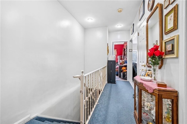 hallway with an upstairs landing and carpet floors