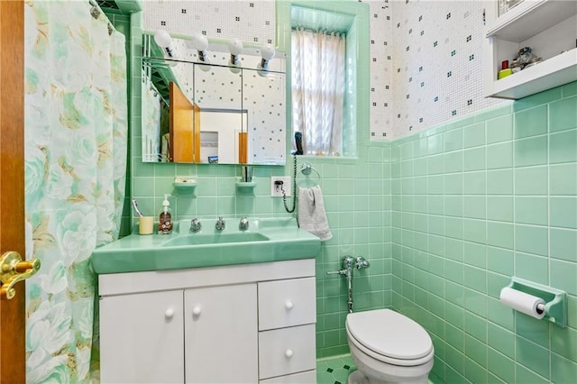 bathroom featuring a shower with shower curtain, vanity, toilet, and tile walls