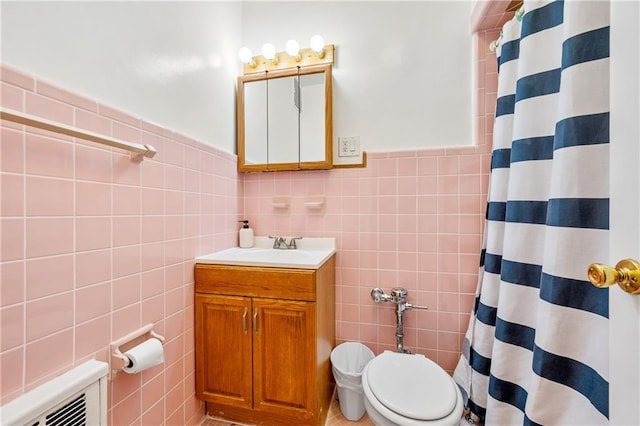 full bathroom with toilet, vanity, wainscoting, a shower with curtain, and tile walls