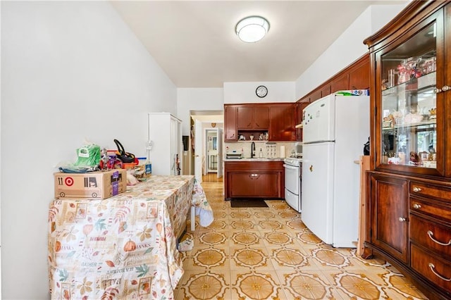 kitchen featuring a sink, white appliances, and light countertops