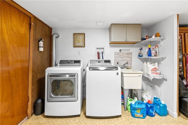 laundry area featuring cabinet space, light floors, and washer and clothes dryer