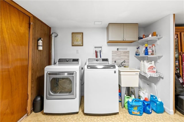 laundry area featuring a sink, cabinet space, and washer and clothes dryer
