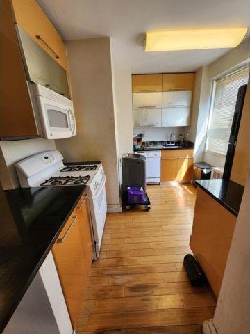 kitchen featuring light wood-type flooring, sink, and white appliances