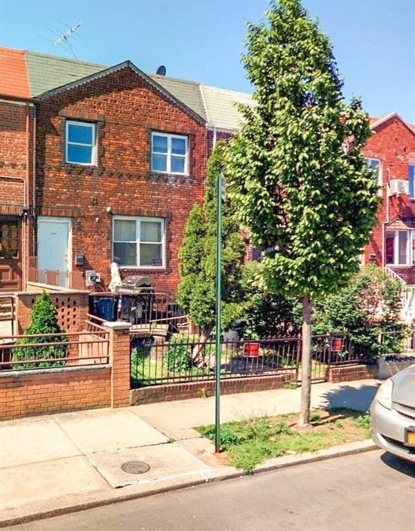 view of property with fence and brick siding