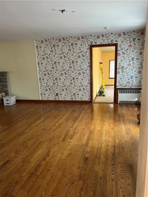 unfurnished room featuring radiator heating unit and wood-type flooring