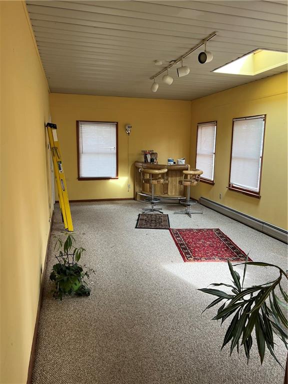 carpeted office with a baseboard radiator