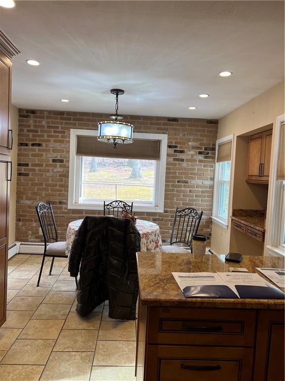 dining space with brick wall, light tile patterned floors, and baseboard heating