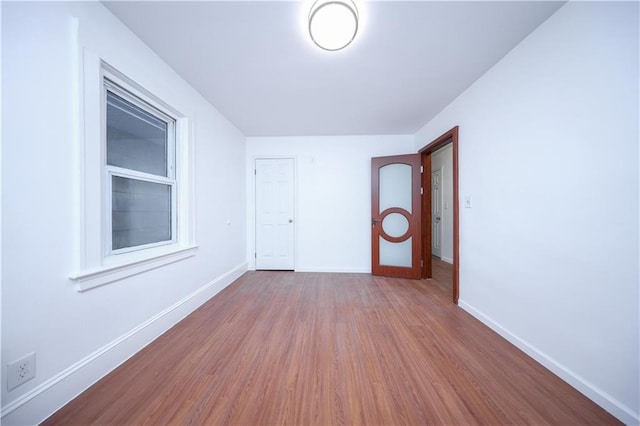 unfurnished room featuring baseboards and wood finished floors