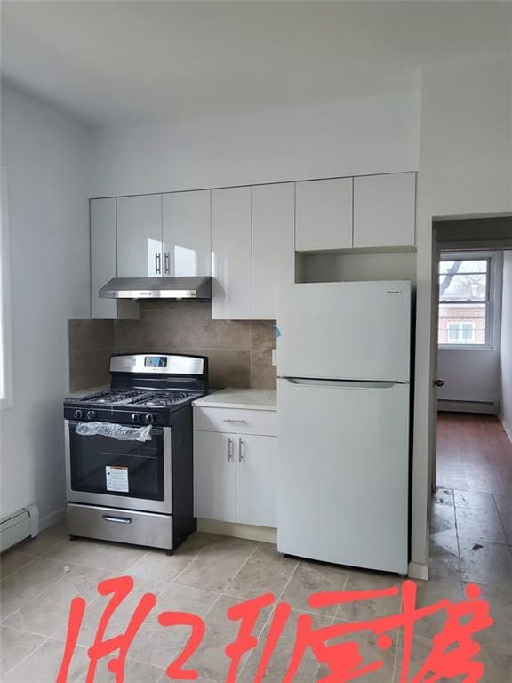 kitchen with a baseboard radiator, gas range, white refrigerator, backsplash, and white cabinetry