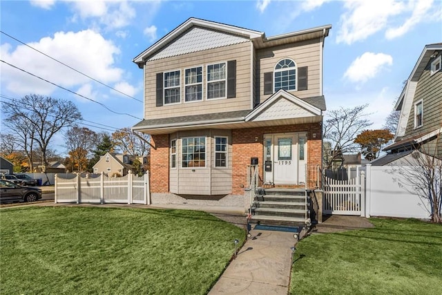 view of front of house featuring fence, a front lawn, and brick siding