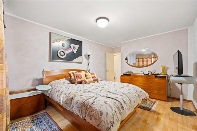 bedroom featuring light hardwood / wood-style floors and ornamental molding