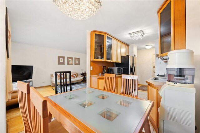 dining space featuring a notable chandelier and light hardwood / wood-style floors