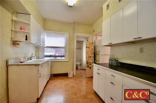 kitchen featuring white cabinets, white fridge, and light parquet floors