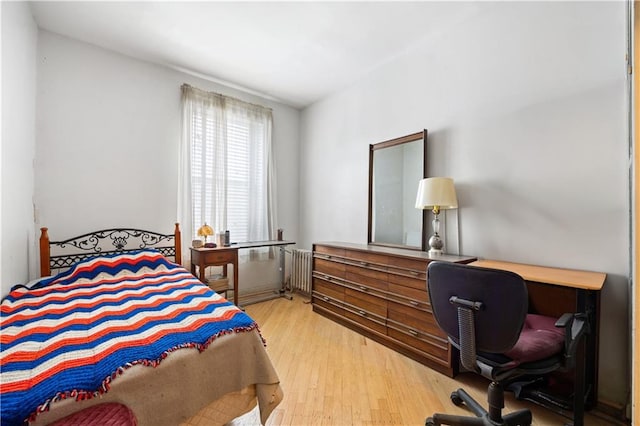 bedroom featuring radiator and light hardwood / wood-style flooring