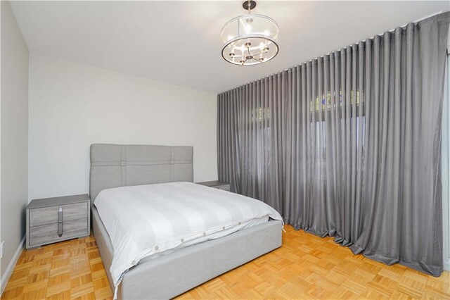 bedroom with light parquet floors and a chandelier