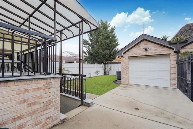 view of patio / terrace with a garage, cooling unit, and an outbuilding