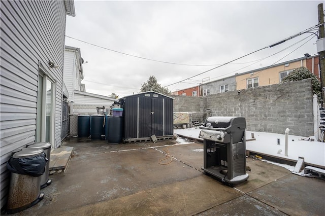 view of patio / terrace featuring an outbuilding, area for grilling, a fenced backyard, and a shed