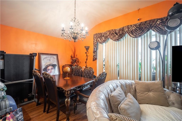 dining space with vaulted ceiling, a notable chandelier, and wood finished floors