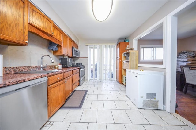 kitchen with backsplash, sink, and appliances with stainless steel finishes