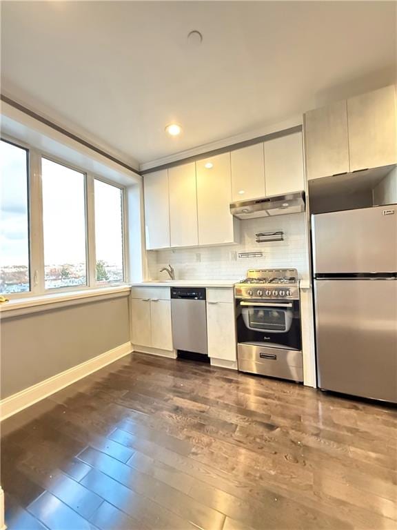 kitchen with backsplash, dark hardwood / wood-style flooring, white cabinetry, and stainless steel appliances