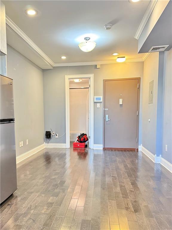 interior space with wood-type flooring and ornamental molding