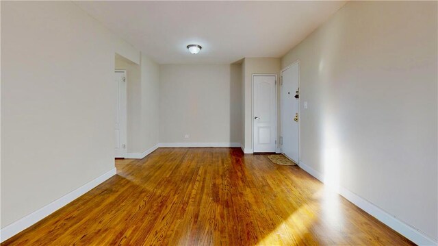 unfurnished room with hardwood / wood-style flooring