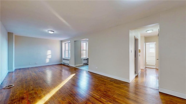 unfurnished room featuring hardwood / wood-style floors and radiator