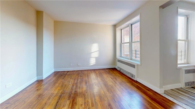 spare room featuring radiator and hardwood / wood-style flooring