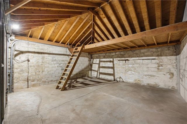 misc room with lofted ceiling and concrete floors