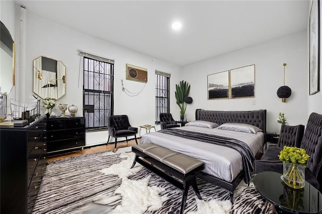 bedroom featuring wood-type flooring and a wall mounted AC