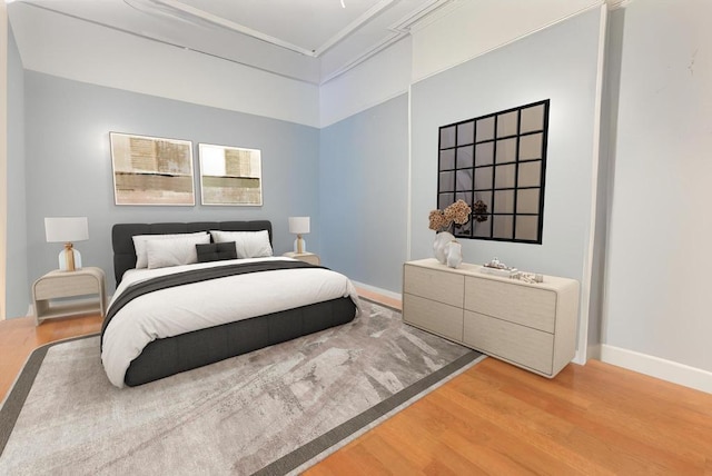 bedroom featuring hardwood / wood-style flooring and crown molding