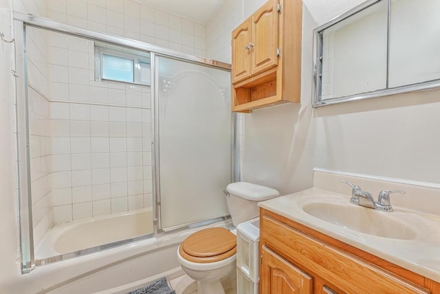 full bathroom with vanity, toilet, and combined bath / shower with glass door